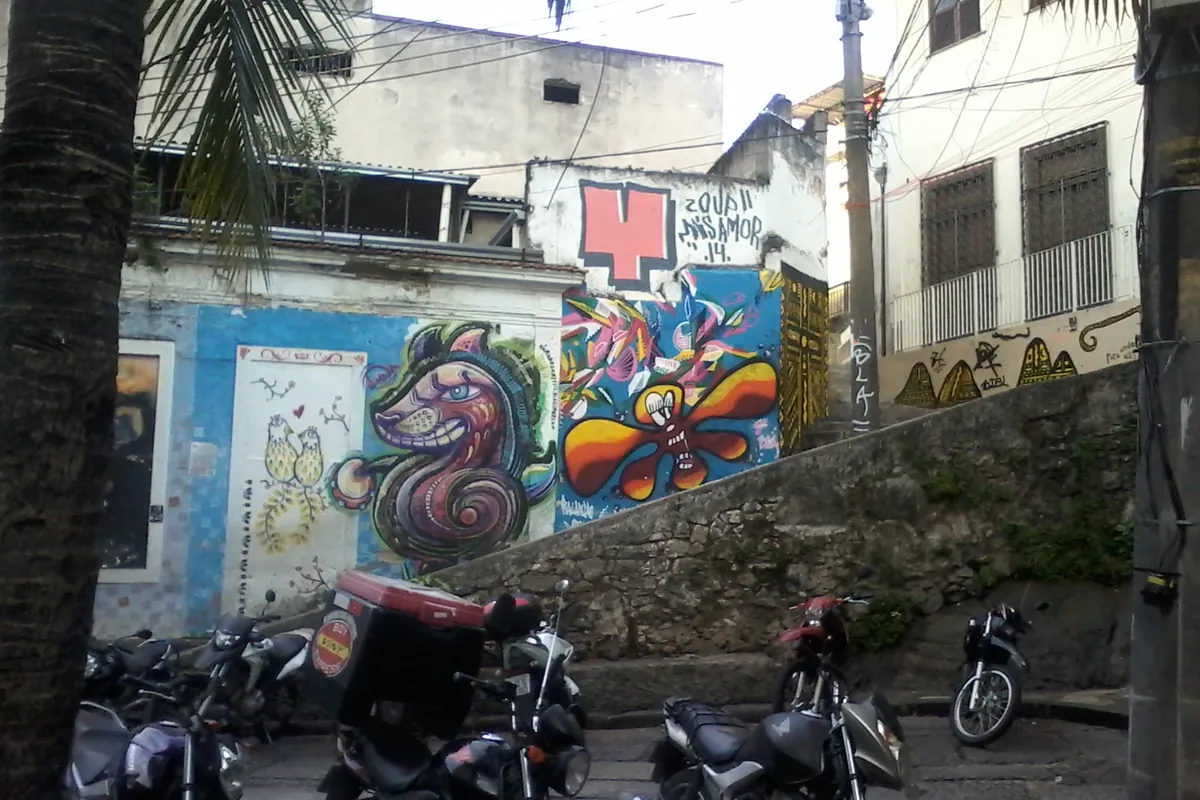 Pedra do Sal seen from the square at its foot, a sloping granite rock with steps, painted walls and low buildings